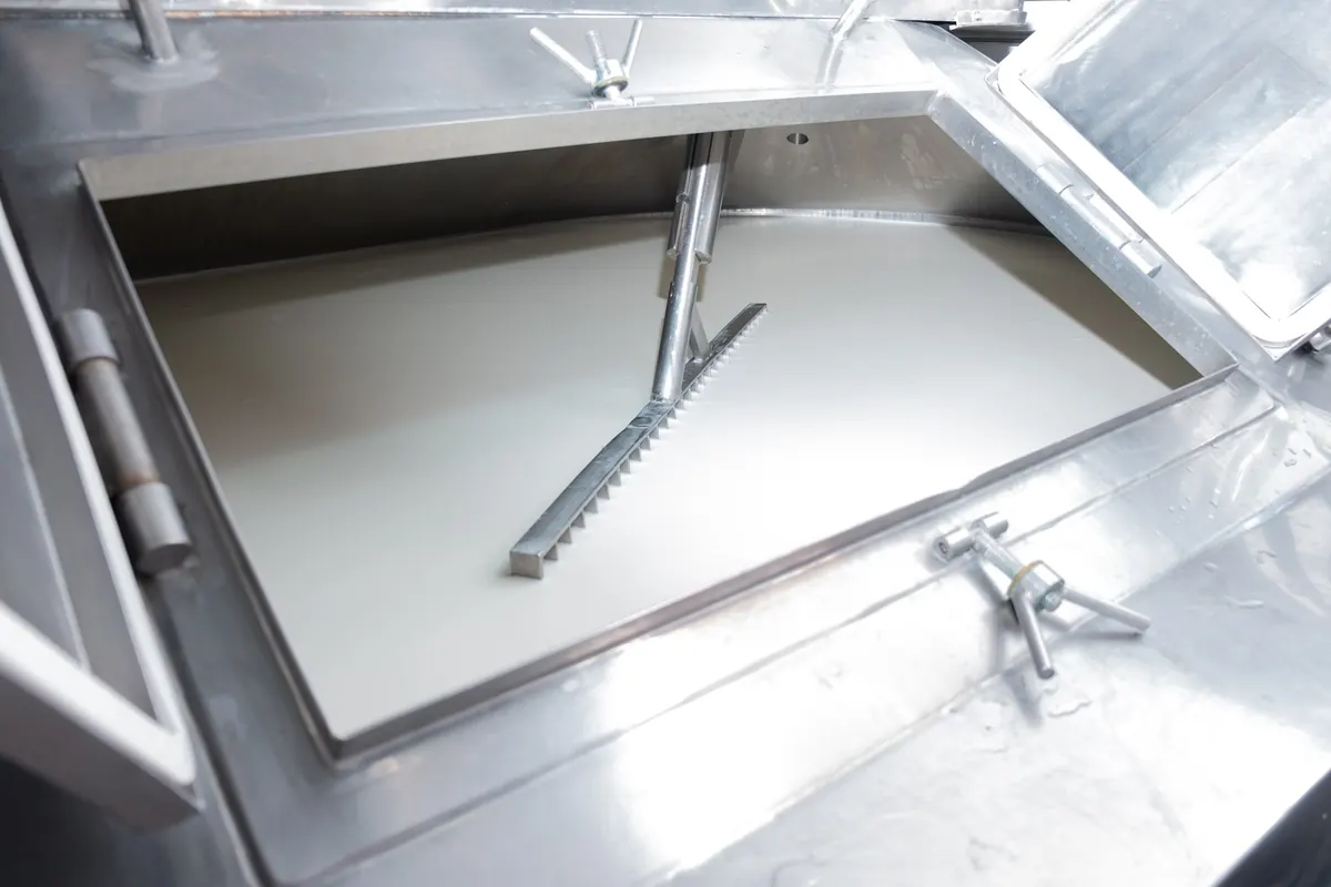 Tanque de inox para fabricação de queijo, limpo, com o leite em repouso